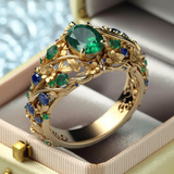 Anillo dorado con cristales verdes y azules