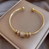 Brazalete ajustable con dijes dorados