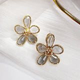 Pendientes giratorios incrustados con zirconia cúbica y Flor de la Riqueza
