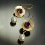 Aretes dorados con detalles morados y perlas