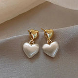 Pendientes elegantes en forma de corazón con perla dorada