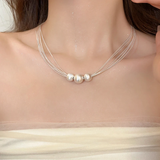 Collar elegante con capas de perlas blancas