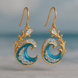 Aretes dorados con ondas brillantes del océano