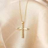 Collar con colgante en forma de cruz con alas de ángel doradas