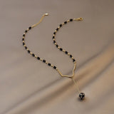 Collar vintage con cuentas negras y un colgante en forma de gota